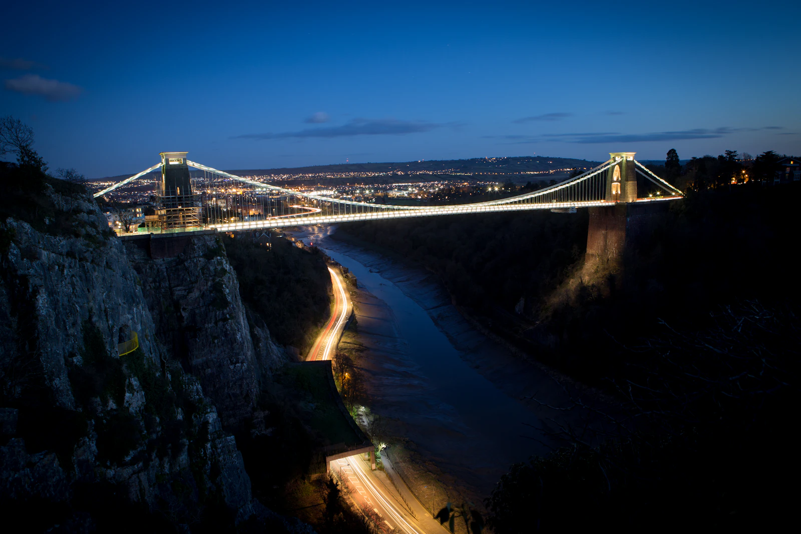 Clifton Suspension Bridge illuminated at dusk, spanning the Avon Gorge